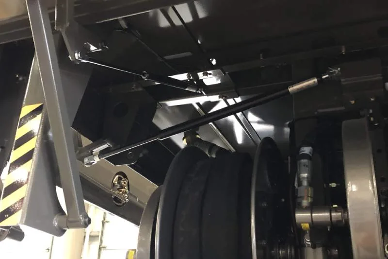 Gas compression spring fitted to a hinged equipment lid
